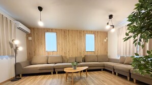 Un saló modern amb un sofà modular, una taula rodona petita i una planta en test.