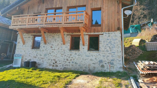 A wooden chalet with a balcony, stone walls, and a Swiss flag. - Chalet les étoiles des Alpes close to ski resorts (Saint-Jean-d'Aulps)