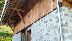 A rustic building with a stone facade, wooden beams, and a metal gutter. - Chalet les étoiles des Alpes close to ski resorts (Saint-Jean-d'Aulps)