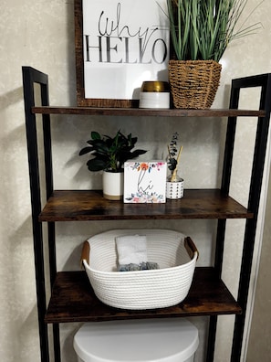 A shelf with a sign saying 'Why HELLO,' a potted plant, a decorative box, and a woven basket. - New!-Our Cozy Farmhouse in Fruitport- welcomes families and pets under 40 lbs (Fruitport)