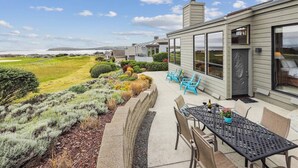 A modern house with a patio, outdoor seating, and a view of the ocean. - Bodega Retreat, by Vinifera Homes (Bodega Bay)