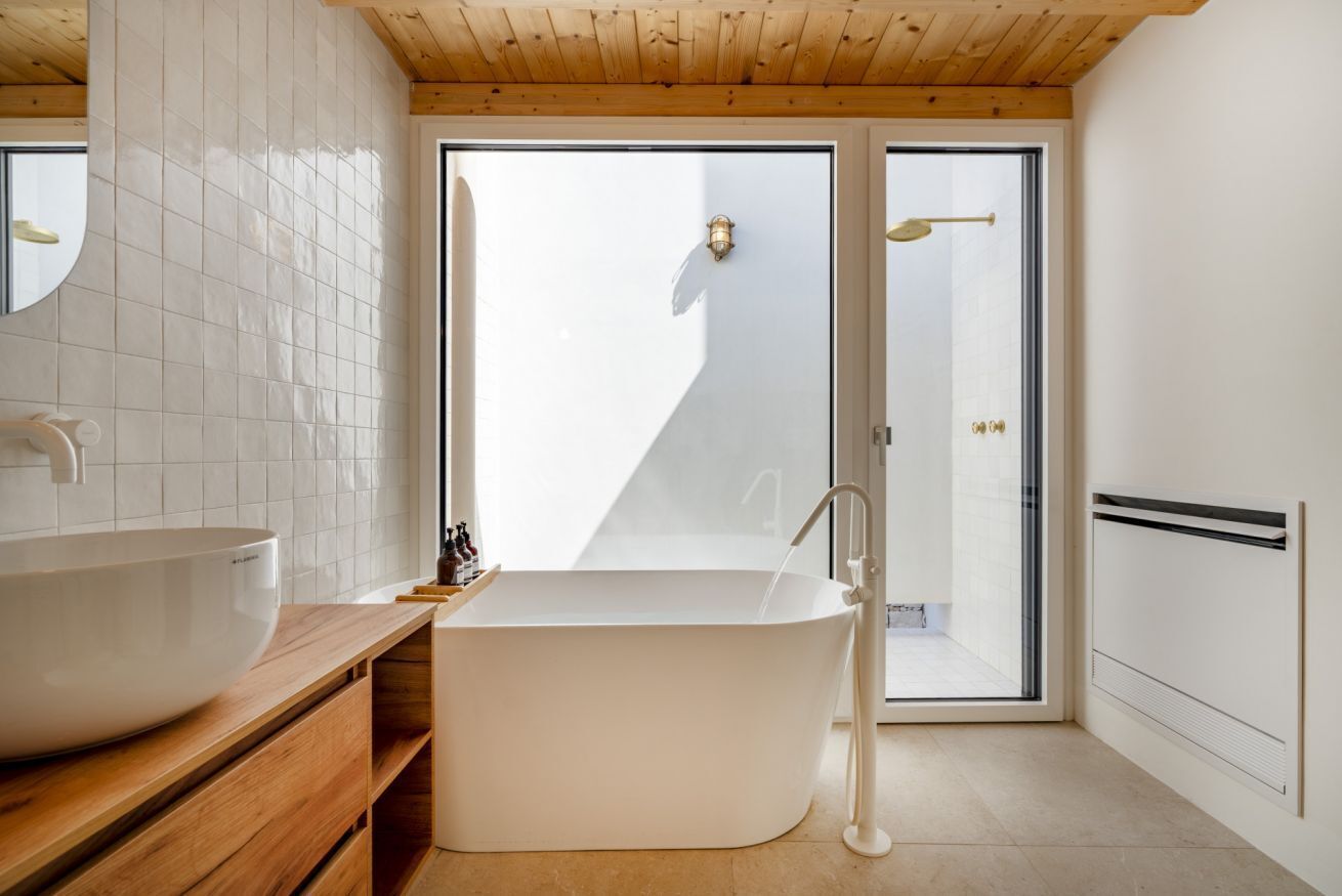 A modern bathroom with a freestanding bathtub, a large vessel sink, and a glass shower enclosure.