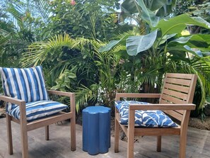 Two wooden chairs with blue and white striped cushions and a matching blue stool.