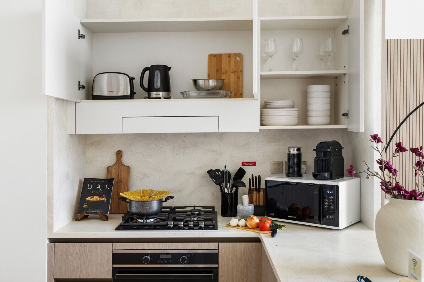 A modern kitchen with a gas stove, microwave, and various kitchen utensils.