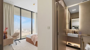 Un dormitorio moderno con un ventanal grande, una cama, una silla y vistas a la ciudad.