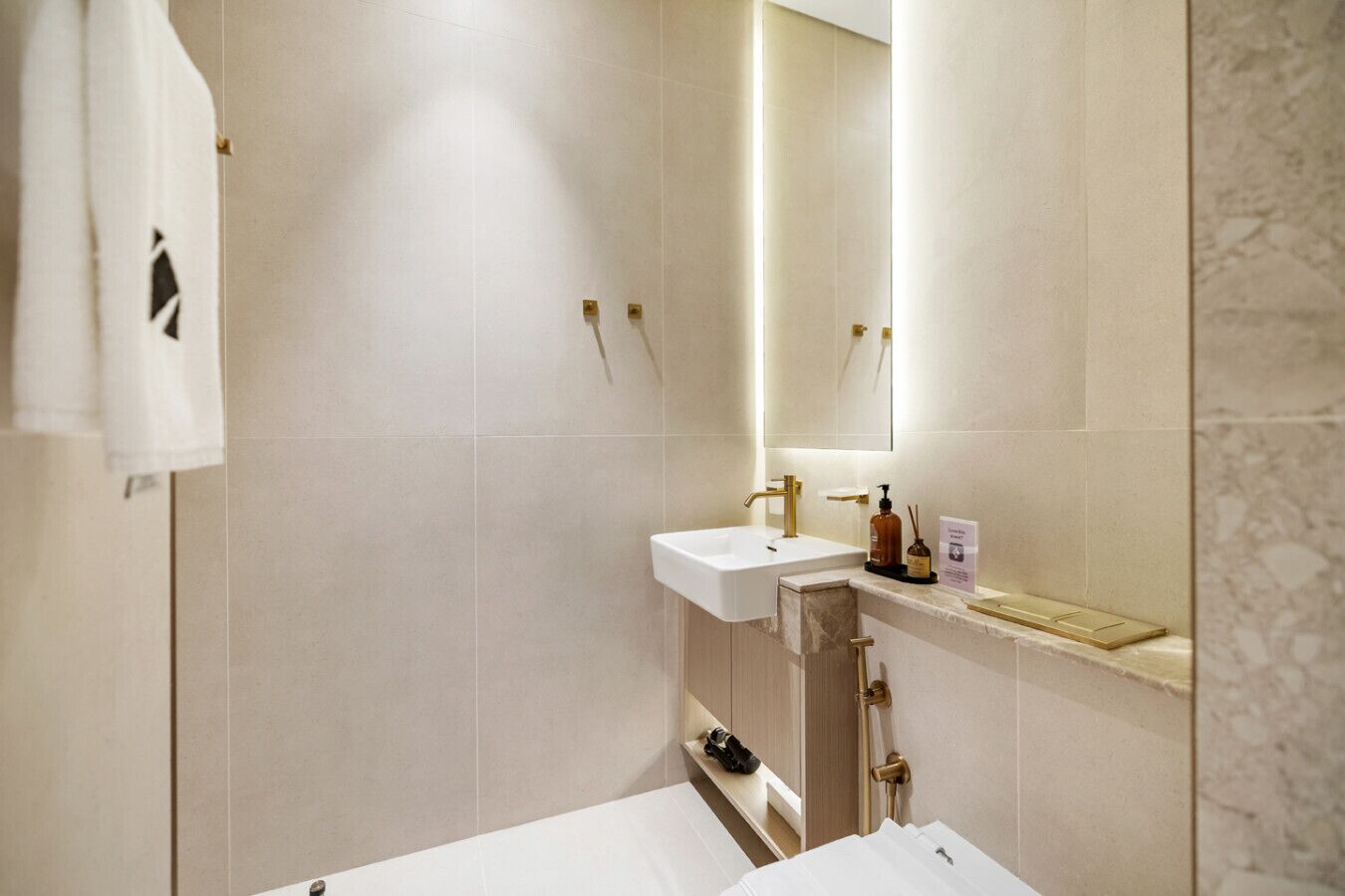 A modern bathroom with a white sink, a mirror, and a shower area.