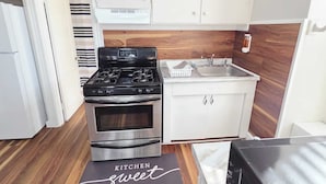 A kitchen with white cabinets, a stainless steel stove, and a sink. - Your favorite space (Schenectady)