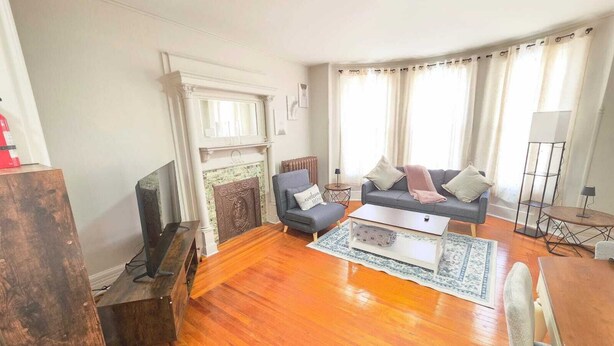 A living room with a fireplace, a sofa, a coffee table, and a TV. - Your favorite space (Schenectady)
