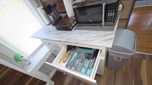 A kitchen with a microwave, a coffee maker, and a drawer with utensils. - Your favorite space (Schenectady)