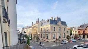 A balcony with a view of a street, a building with classical architecture, and a clear sky. - Studio Saint-Germain-en-Laye -RER A- Near Paris (Saint-Germain-en-Laye)