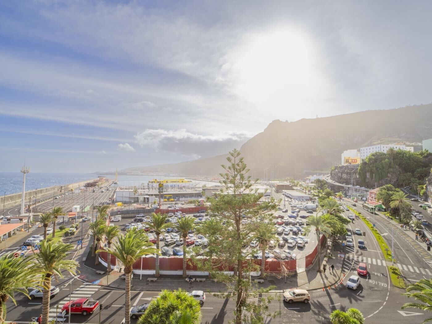 Un paisaje urbano costero con un estacionamiento, carreteras y vistas al mar.