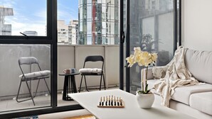 Een moderne woonkamer met een schaakbord op een bijzettafeltje, een bank en twee fauteuils.