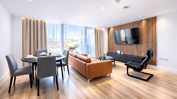 Una sala de estar moderna con comedor, sofá de cuero y un televisor de pantalla plana montado en una pared de madera.