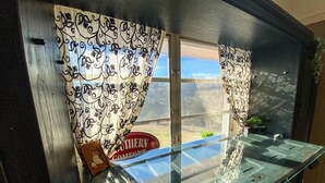 A glass display table with a vintage sign reading "Southern Comfort" and a small brown box. - 3 Bedroom Mid Century Brick Ranch Upstairs Home Near Smokies (Sevierville)