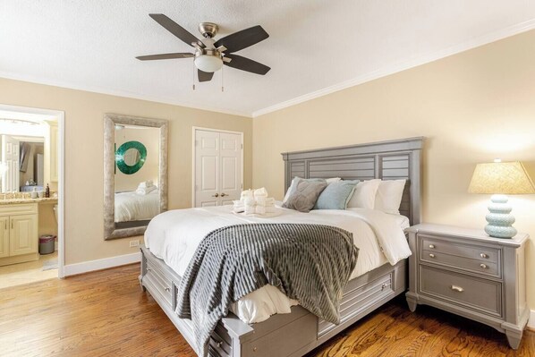 A bedroom with a bed, nightstand, dresser, and a ceiling fan. - Downtown Walk | 2 Suites | Free Parking (Atlanta)