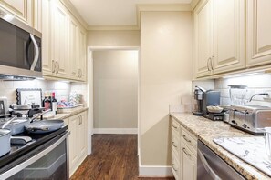 A kitchen with white cabinets, a microwave, a toaster, and a coffee maker. - Downtown Walk | 2 Suites | Free Parking (Atlanta)