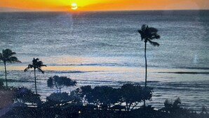 A sunset over the ocean with palm trees and a beach in the foreground. - Hilton Vacation Club Point At Poipu 2-bedroom resort in  Koloa with cool AC (Koloa)