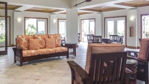 A spacious indoor area with a sofa, dining table, and chairs. - Hilton Vacation Club Point At Poipu 2-bedroom resort in  Koloa with cool AC (Koloa)