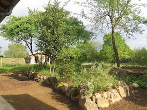 A rural landscape with a dirt path, stone wall, and a small building with a sloped roof. - Au temps des Fleurs - Chez Mamiecha (BAGE-DOMMARTIN)