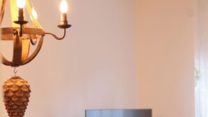 A dining area with a chandelier, a table, a chair, a decorative bowl, and a painting on the wall. - Späth Business Apartment Furnished 2-room basement in Schwanstetten (Schwanstetten)