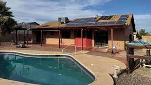 A house with a swimming pool, solar panels, and a basketball hoop. - Cozy 1-bedroom house in awesome Mesa with cool AC (Mesa)