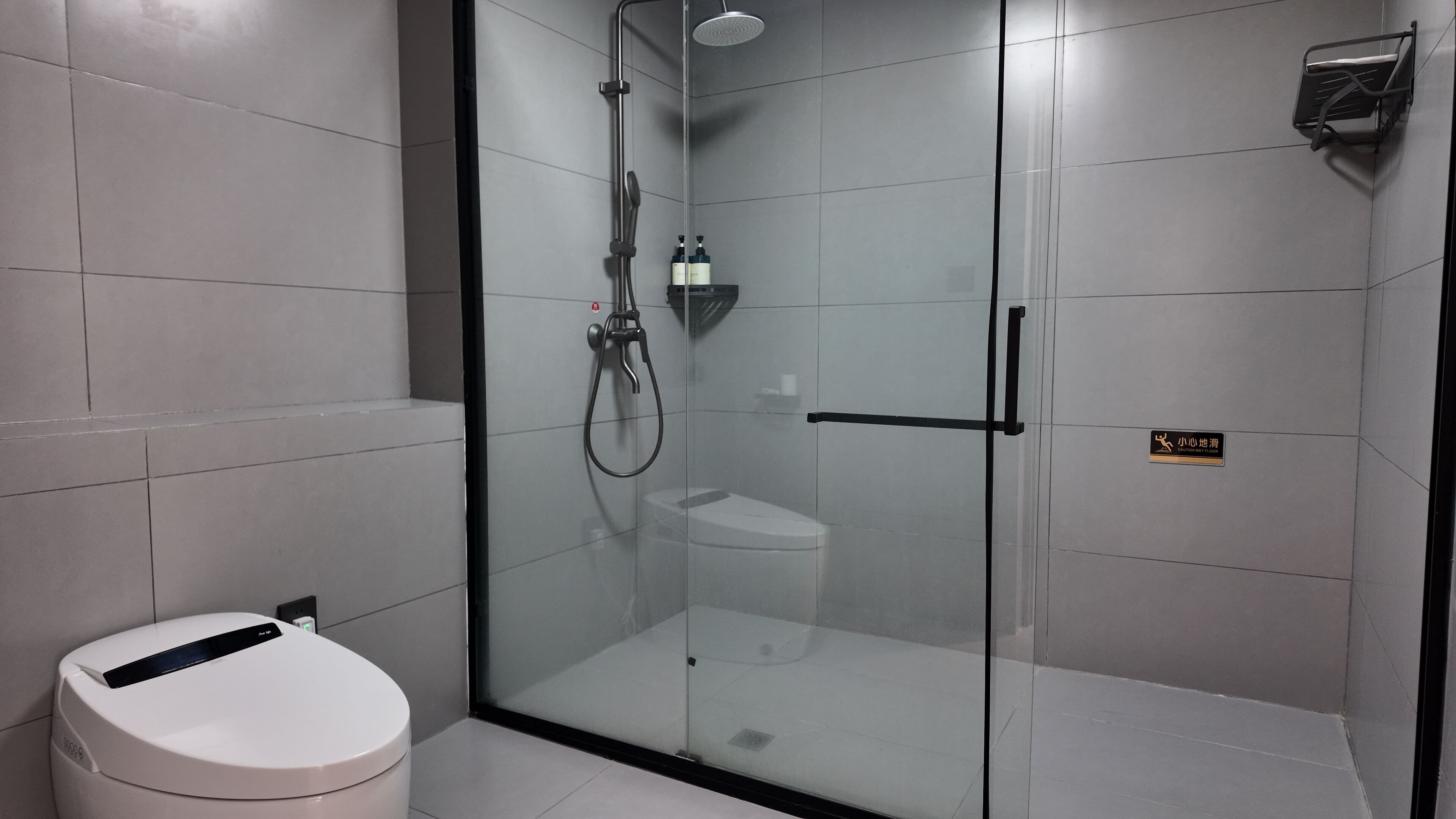 Un baño moderno con ducha de vidrio, inodoro y lavamanos.