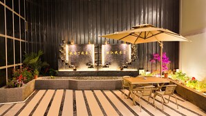 An outdoor seating area with a table and chairs, a decorative water feature with Chinese characters, and potted plants. - Ancient City District Ai Shan Hotel (Lijiang)