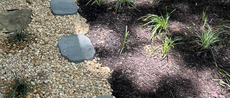 A garden pathway with stepping stones and gravel.