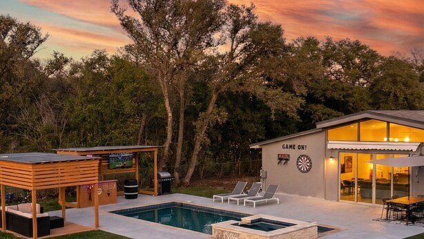 A modern house with a swimming pool, a covered patio, and a game room. - Luxury house with heated pool+Movie theatre room next to sixflags and la cantera (San Antonio)