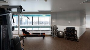 A gym with a rowing machine, exercise balls, and dumbbells. - Spacious landmark in the heart of Mel CBD (Melbourne)