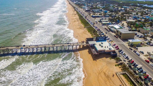 An aerial view of Flagler Beach with a pier, beach, and adjacent urban area. - Waterfront Retreat With Pool Tiki Bar Boat Dock (Palm Coast)