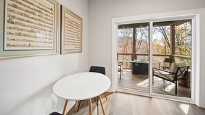 A room with a large window, a white table, and two framed pictures on the wall. - Cozy Cottage in Yonahlossee Racquet Club (Boone)