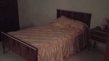 Una camera da letto con un letto, un comodino e un quadro appeso al muro.