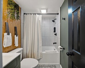 Un baño con inodoro, lavamanos, ducha y puerta.