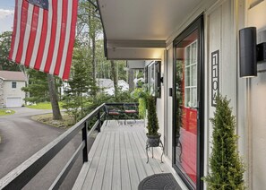 A wooden deck with a railing, a door with a red frame, and a mailbox. - Summit Home - The Ultimate Summit of Style for 12 (Tobyhanna)