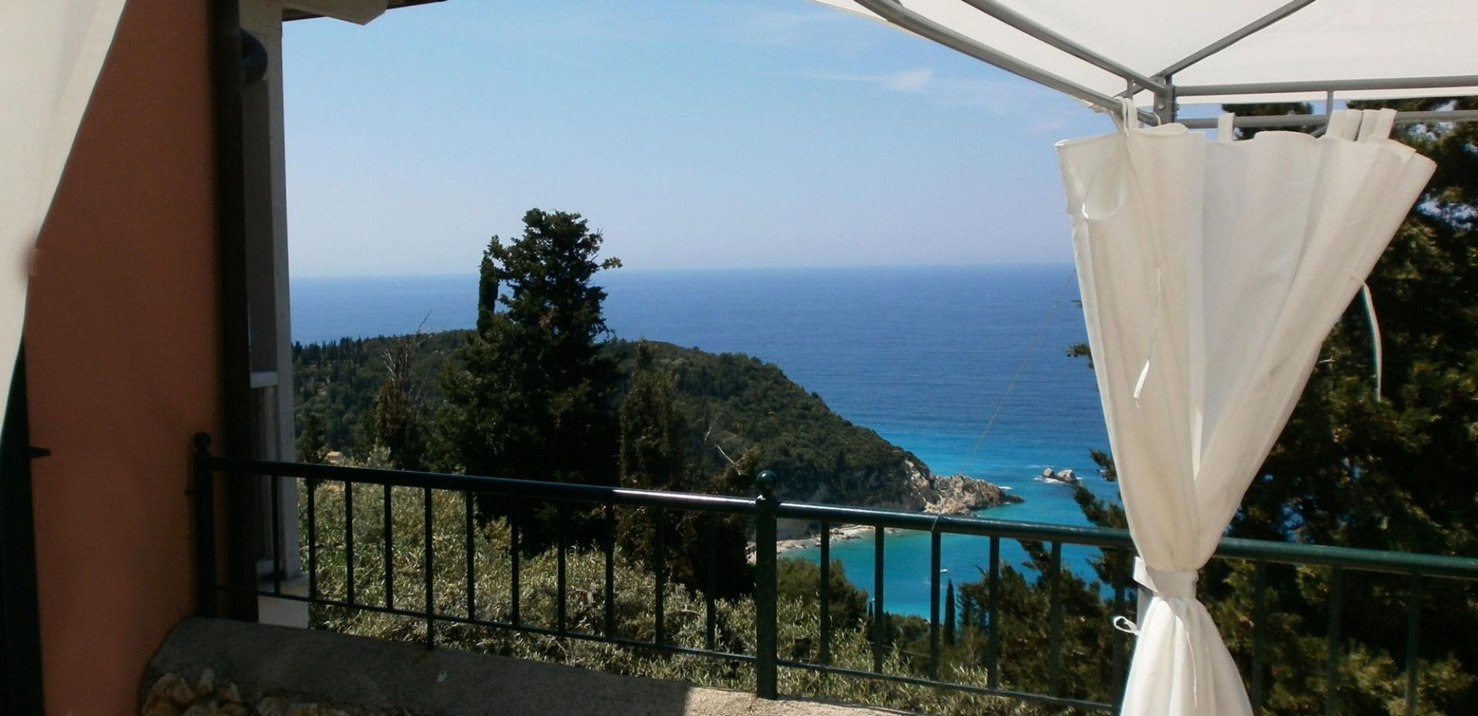Un balcón con vista al mar y un paisaje montañoso.