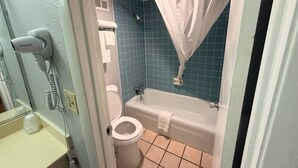 Une salle de bain équipée de toilettes, d’une baignoire et d’un porte-serviettes.