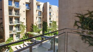 A balcony with a view of a pool and apartment buildings. - Stay & Relax: Fully Equipped Loft in Los Cabos (Cabo San Lucas)