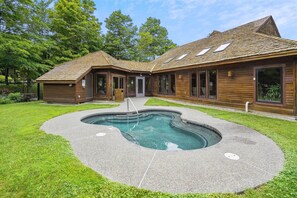 A two-story wooden house with a swimming pool in the backyard. - Ski-in queen hotel room with pool, hot tub, and Wi-Fi. (Killington)
