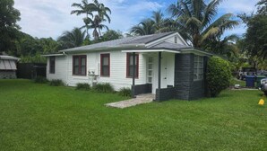 Une maison de plain-pied avec un porche à l’avant, un petit jardin devant et un garage.