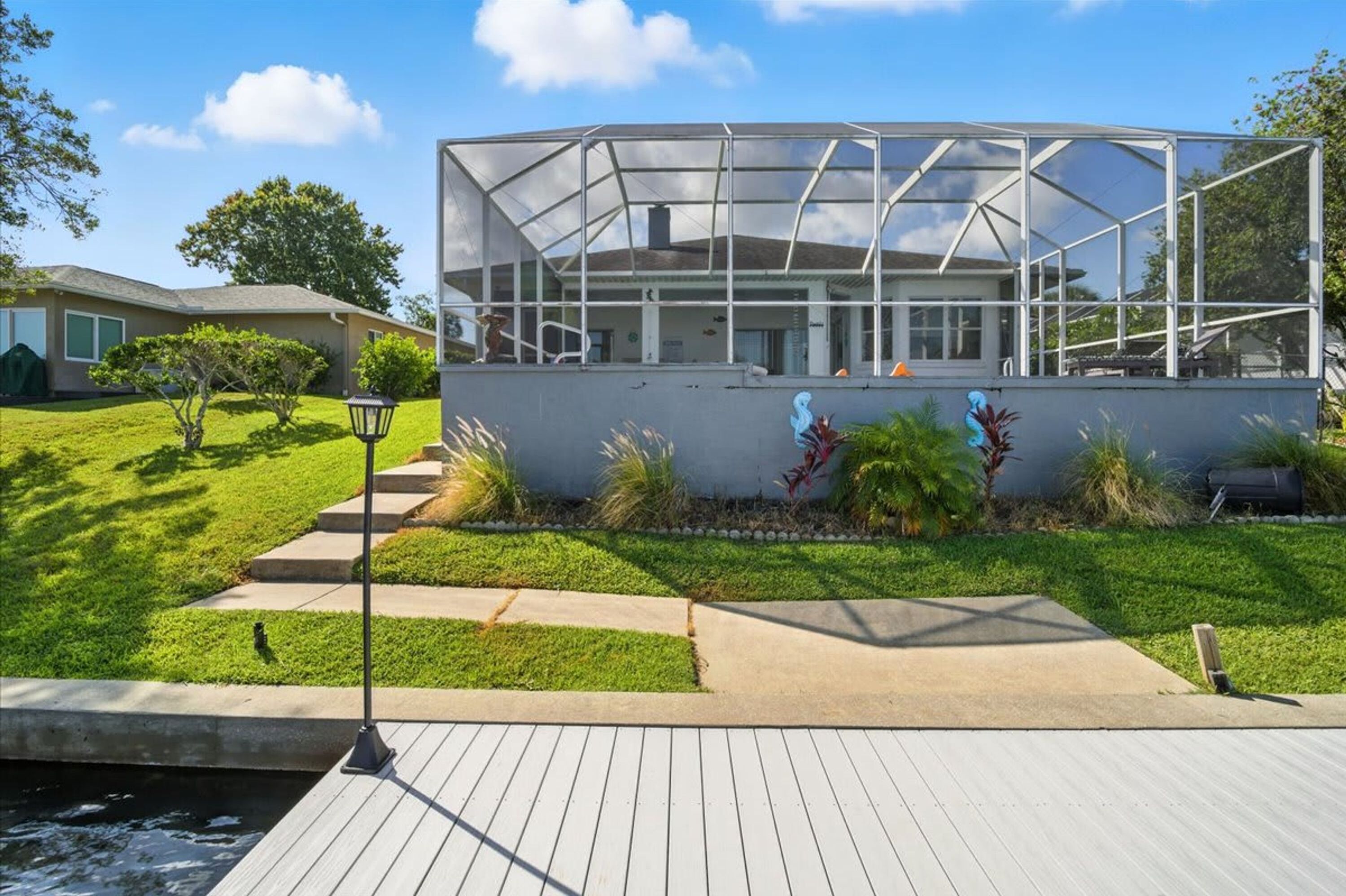 A house with a large glass greenhouse structure attached to the back.