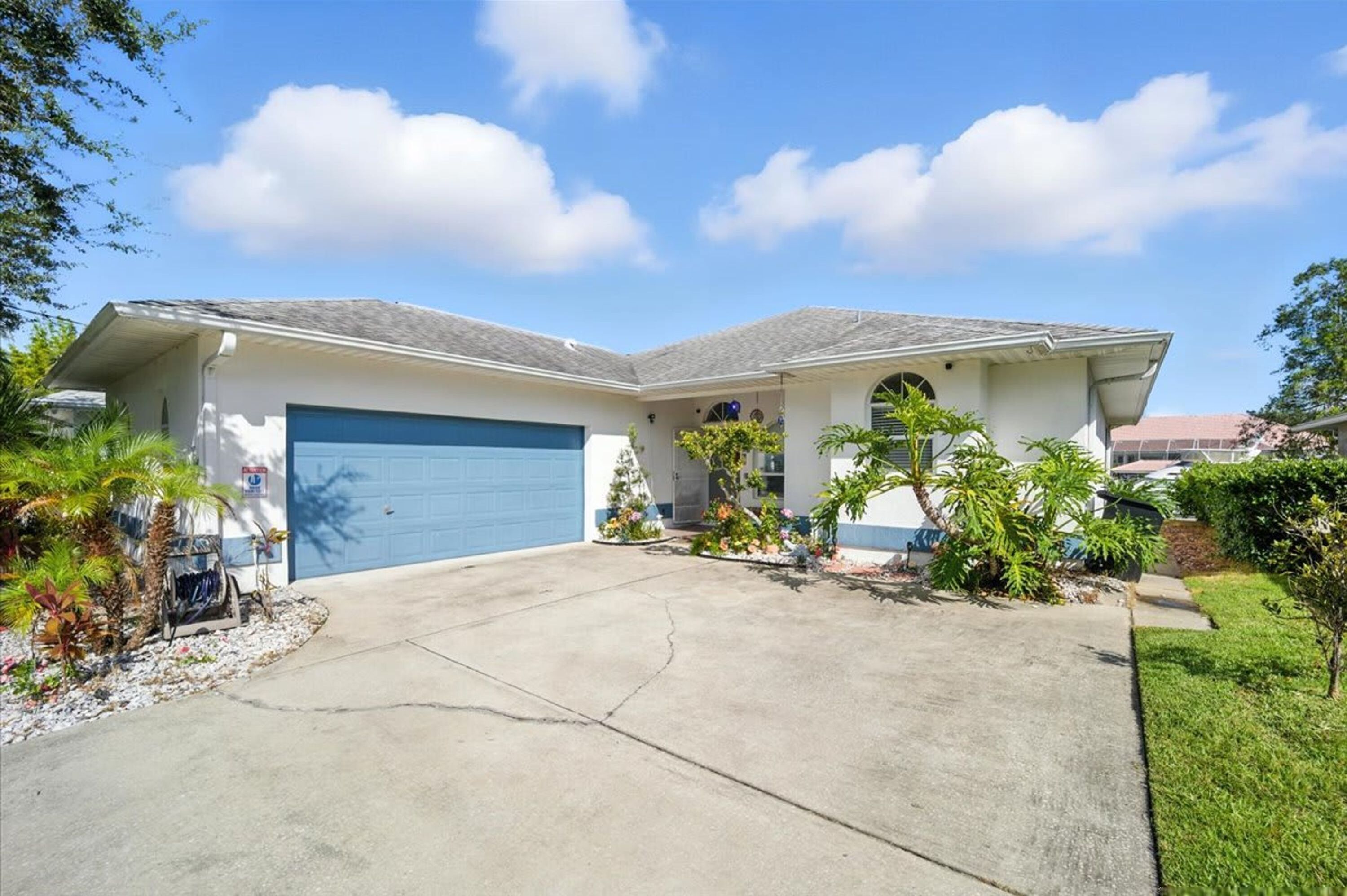 A two-story house with a blue garage door, a covered front porch, and a driveway.