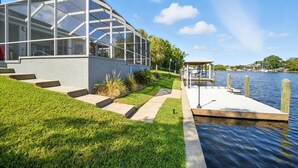 Et moderne hus med et glasmagasin, en dock og udsigt til vandet.