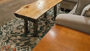 Une pièce chaleureuse avec un plancher en bois, un canapé, une table basse et un escalier menant à une autre pièce.