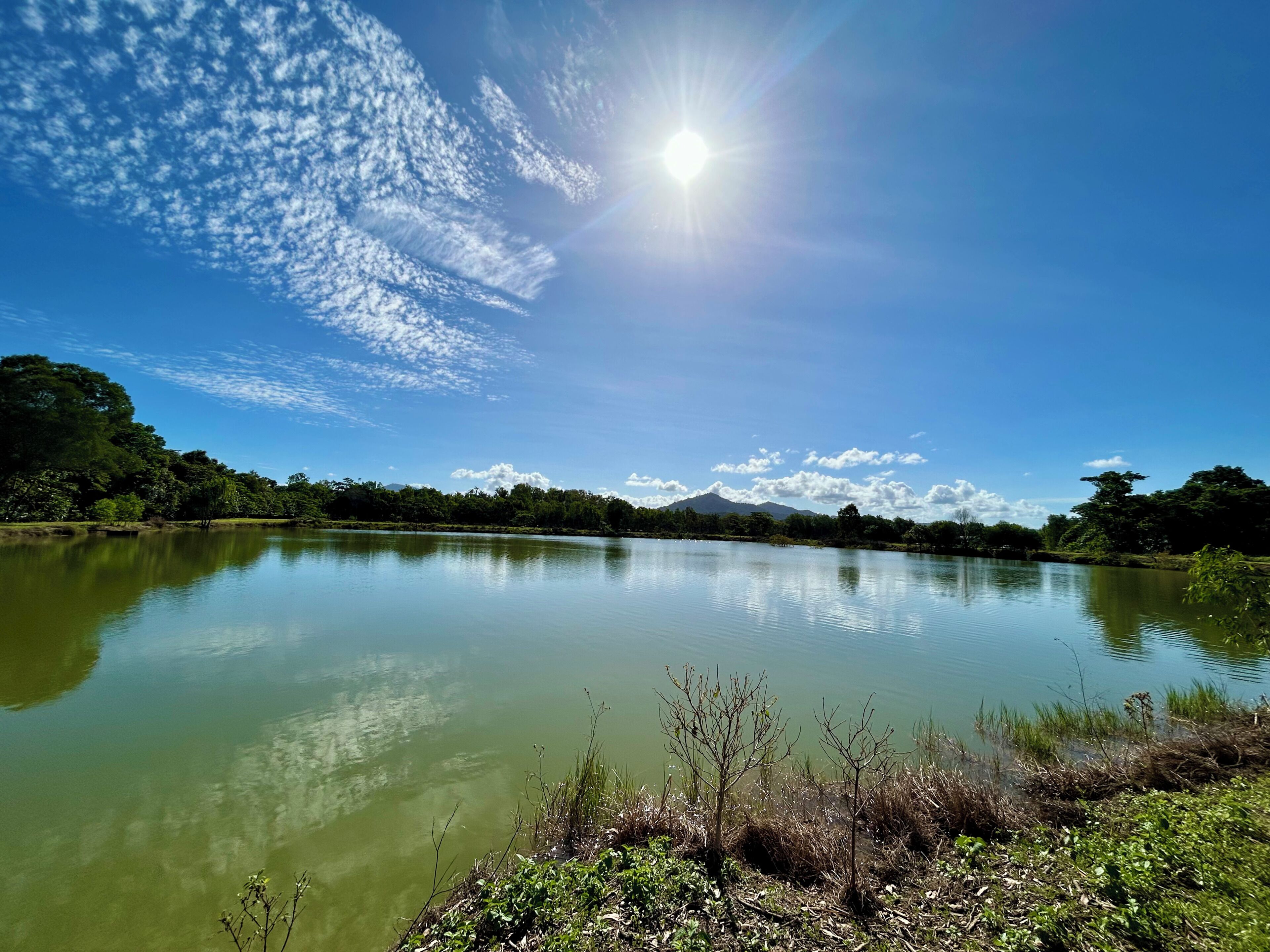 Een rustig meer met een berg op de achtergrond en een heldere lucht.