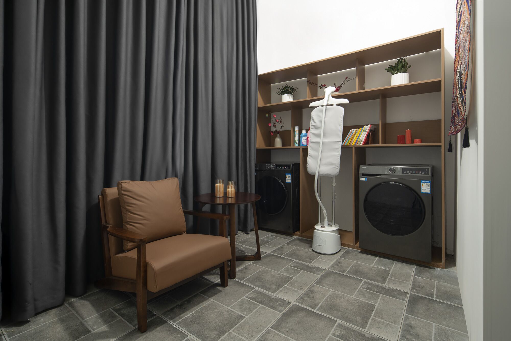 Un espace buanderie compact comprenant un lave-linge, un sèche-linge et une chaise.