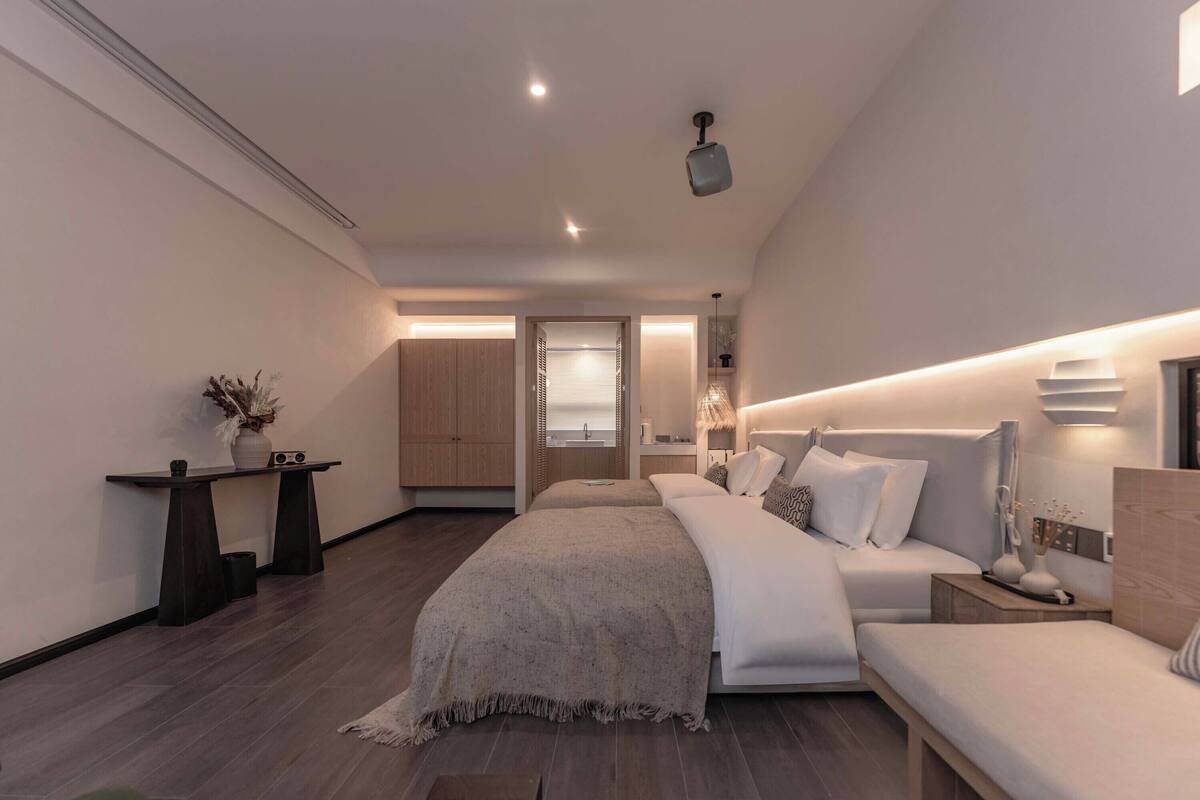 A modern bedroom with a large bed, bedside tables, and a nightstand.