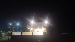 Een klein, verlicht gebouw in de nacht met een plat dak en één ingang.
