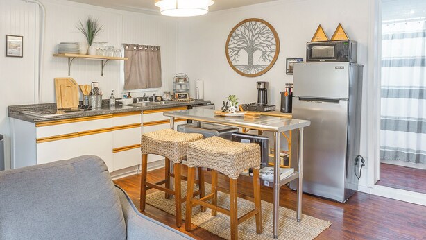 A compact kitchen with a central island, a refrigerator, and a microwave.
