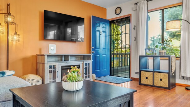 Ein modernes Wohnzimmer mit Kamin, einer blauen Tür und Blick ins Freie.